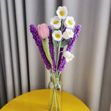 Crocheted flower bouquet in a glass vase on a yellow table