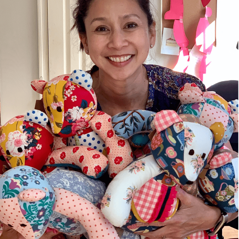 Jen smiles holding handmade fabric bears