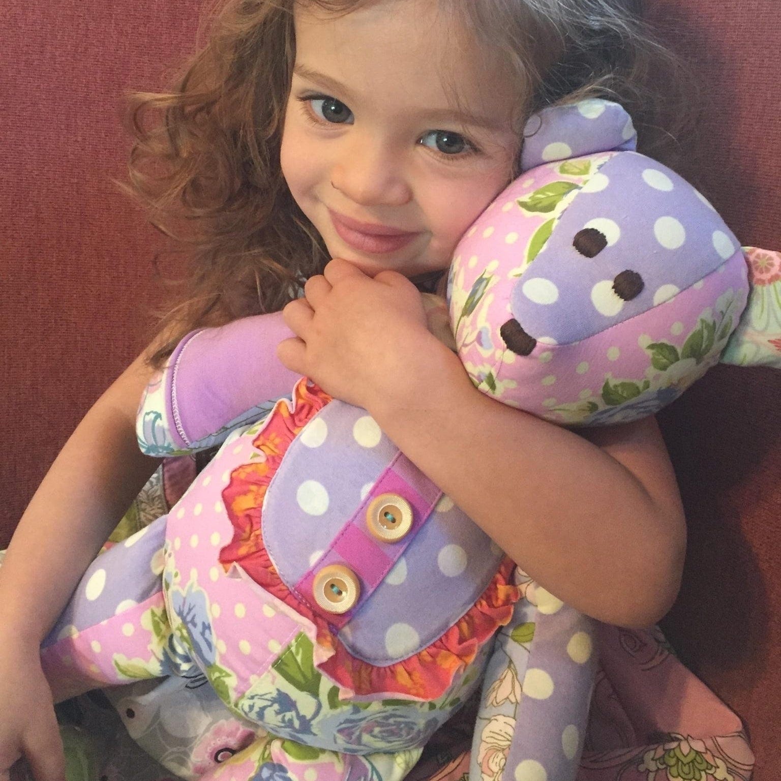Kid hugging polka dot teddy bear