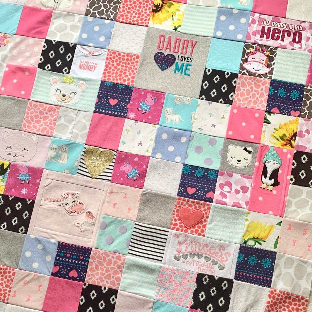 Baby clothes quilt detail with loving messages.