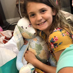 Smiling girl hugging a stuffed bunny.
