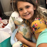 Smiling girl hugging a stuffed bunny.