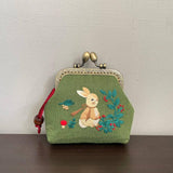 Green coin purse with embroidered bunny.