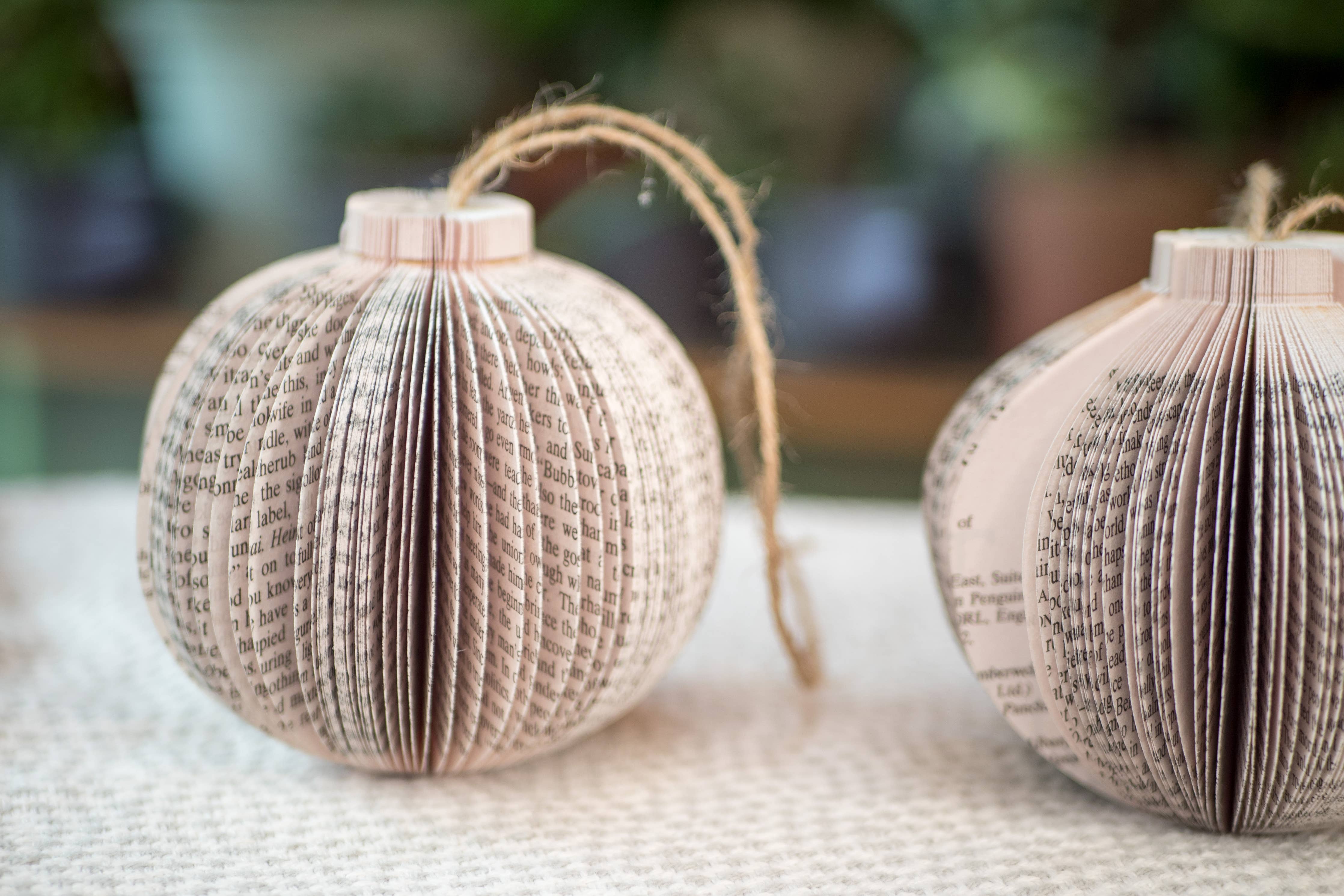 Two paper book page Christmas ornaments.
