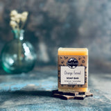 Orange fennel soap bar with a vase of flowers.