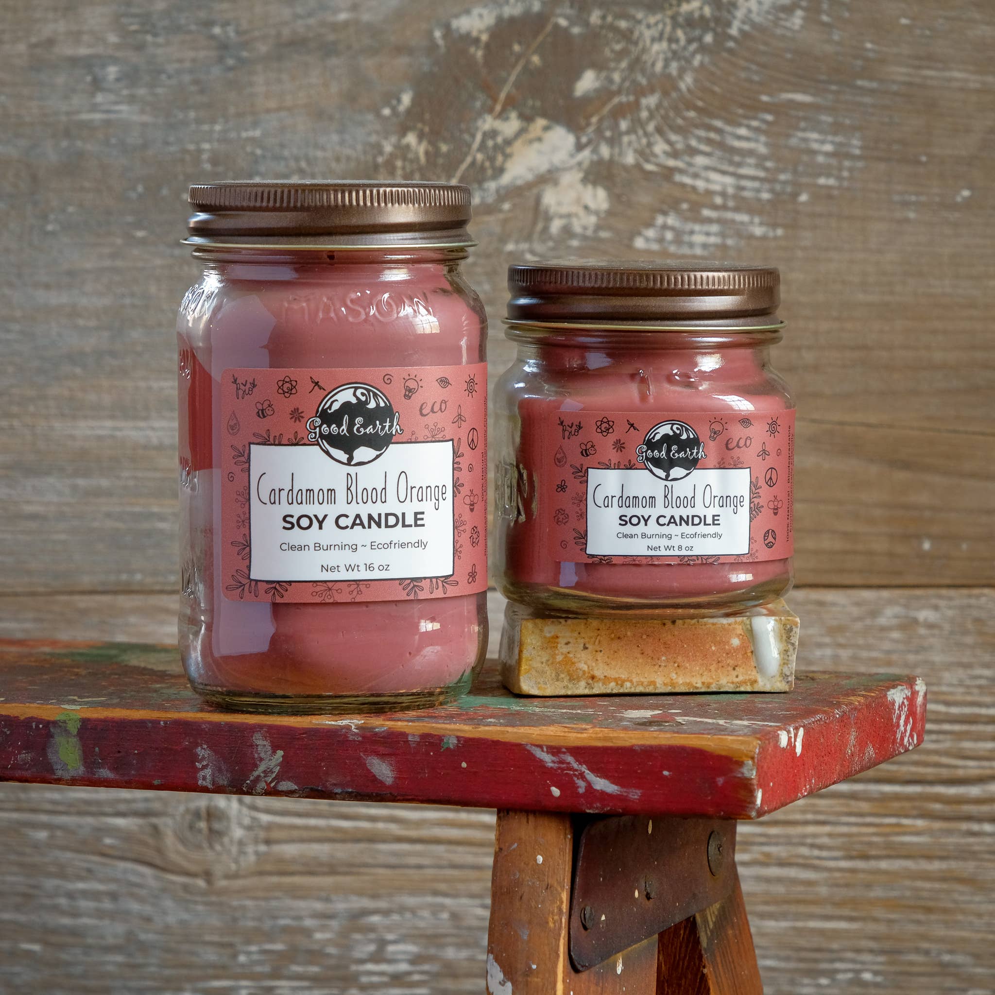 Two pink soy candles in mason jars.