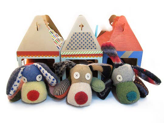 Three stuffed animal dogs with colorful houses.