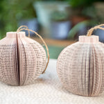 Paper book page ornaments with twine hangers.