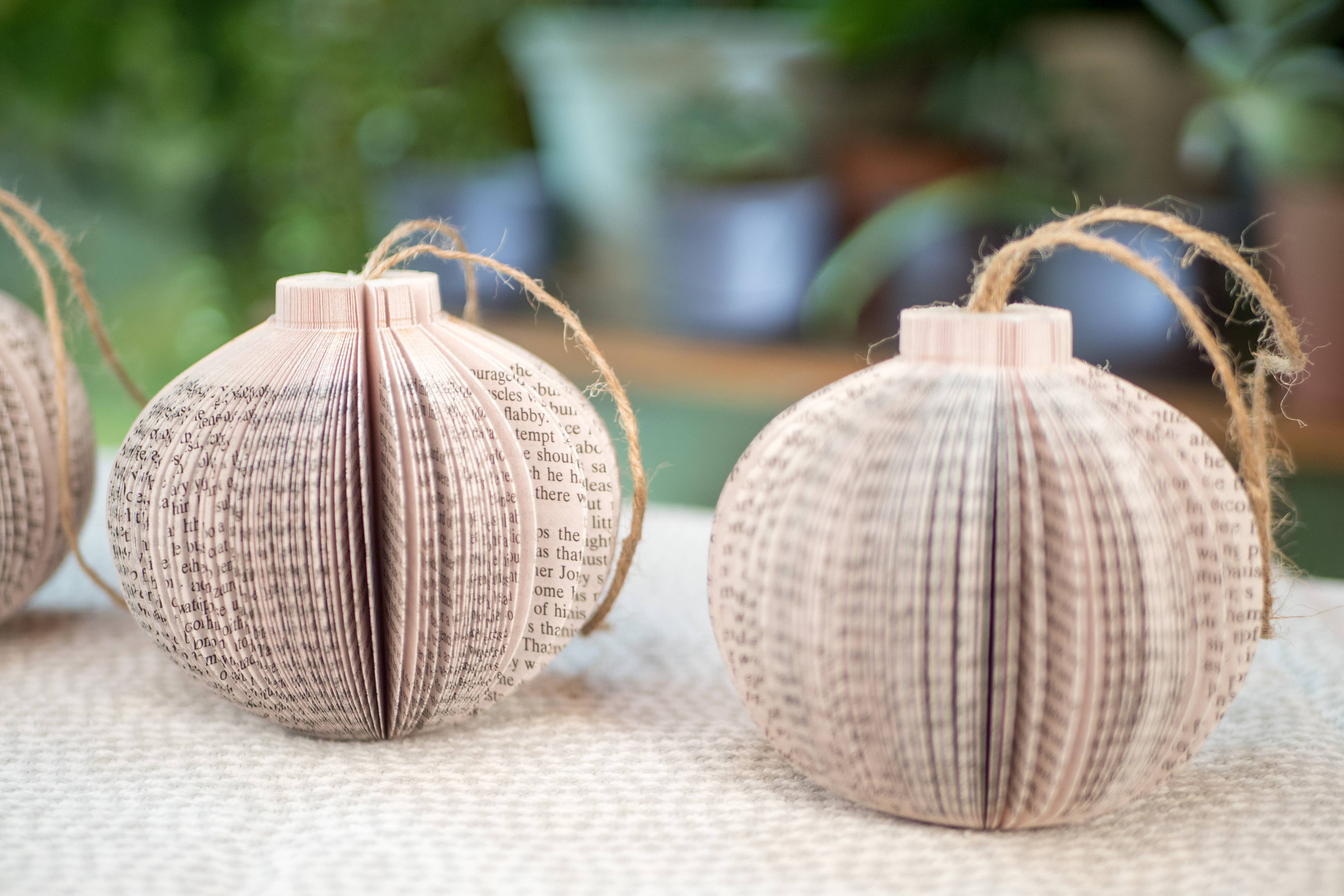 Paper book page ornaments with twine hangers.