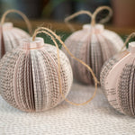 Paper book page ornaments with twine loops.
