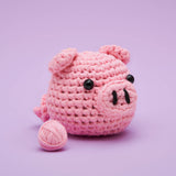 Crocheted pink pig with yarn ball.