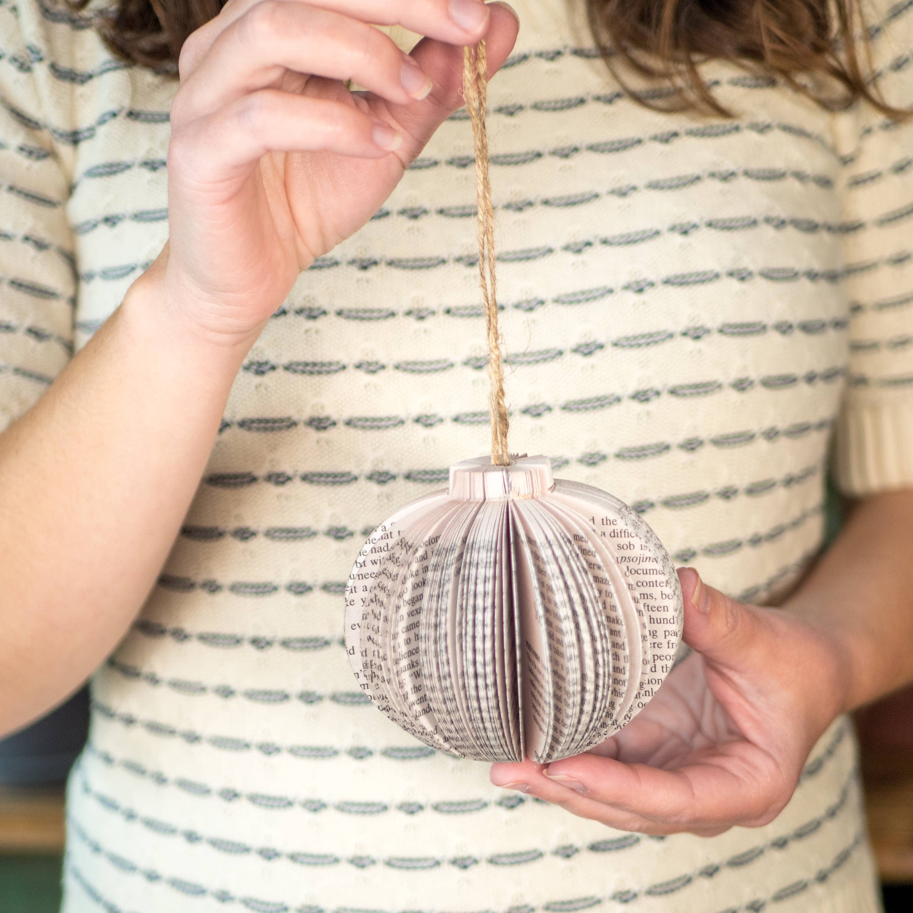 Woman holding a paper ornament.