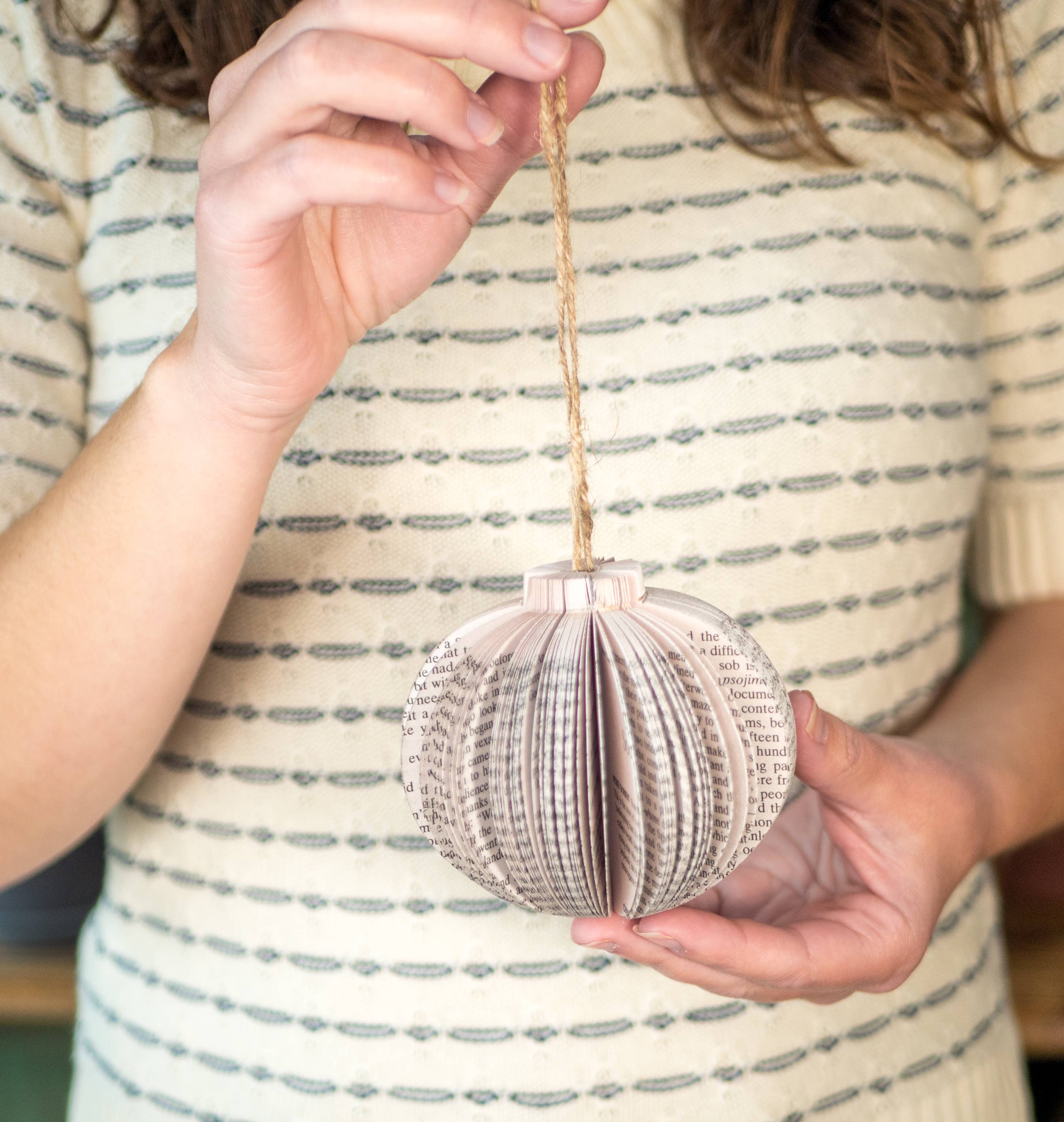 Woman holding a paper ornament.
