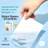 Hand holding a white laundry sheet.