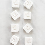 White square tablets with dinosaur footprint imprints.