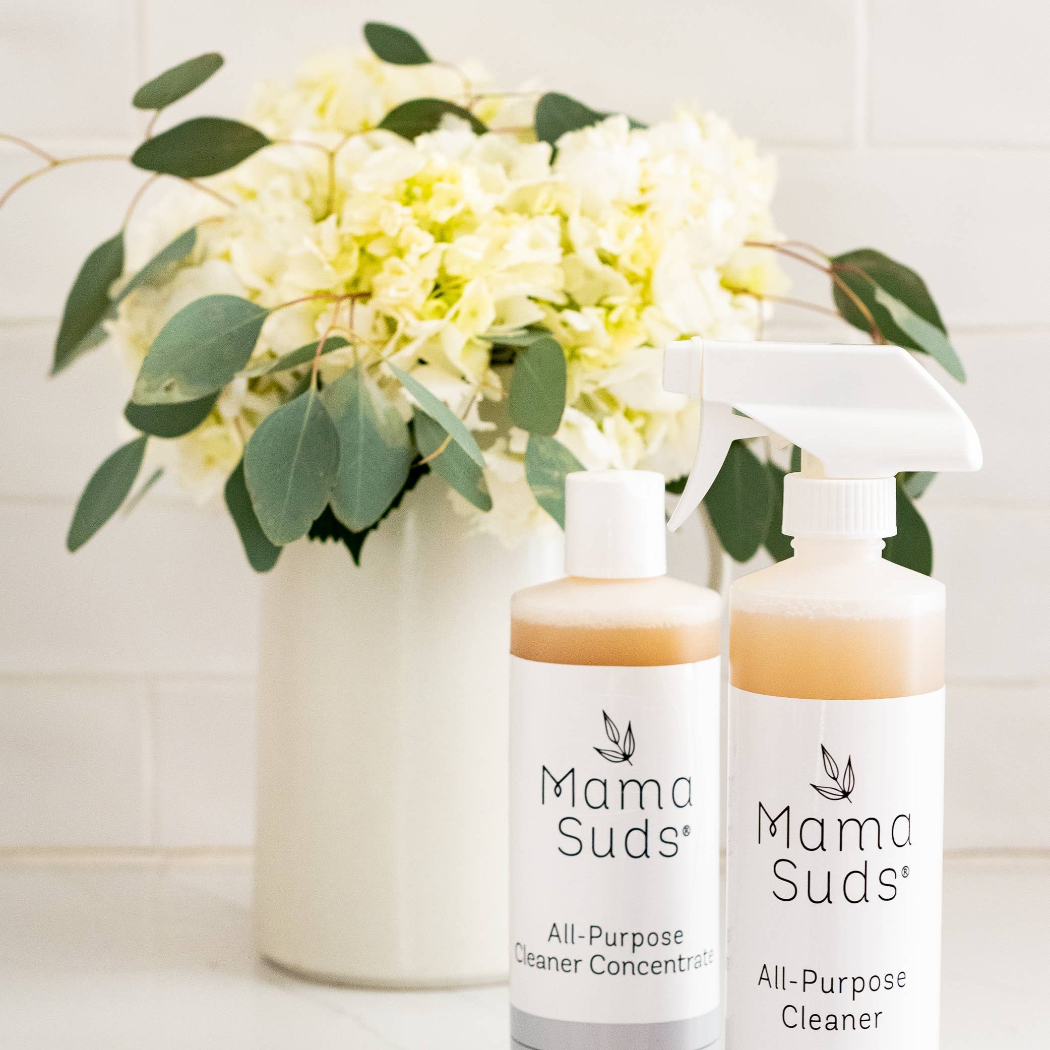 Cleaning products and flowers on a countertop.