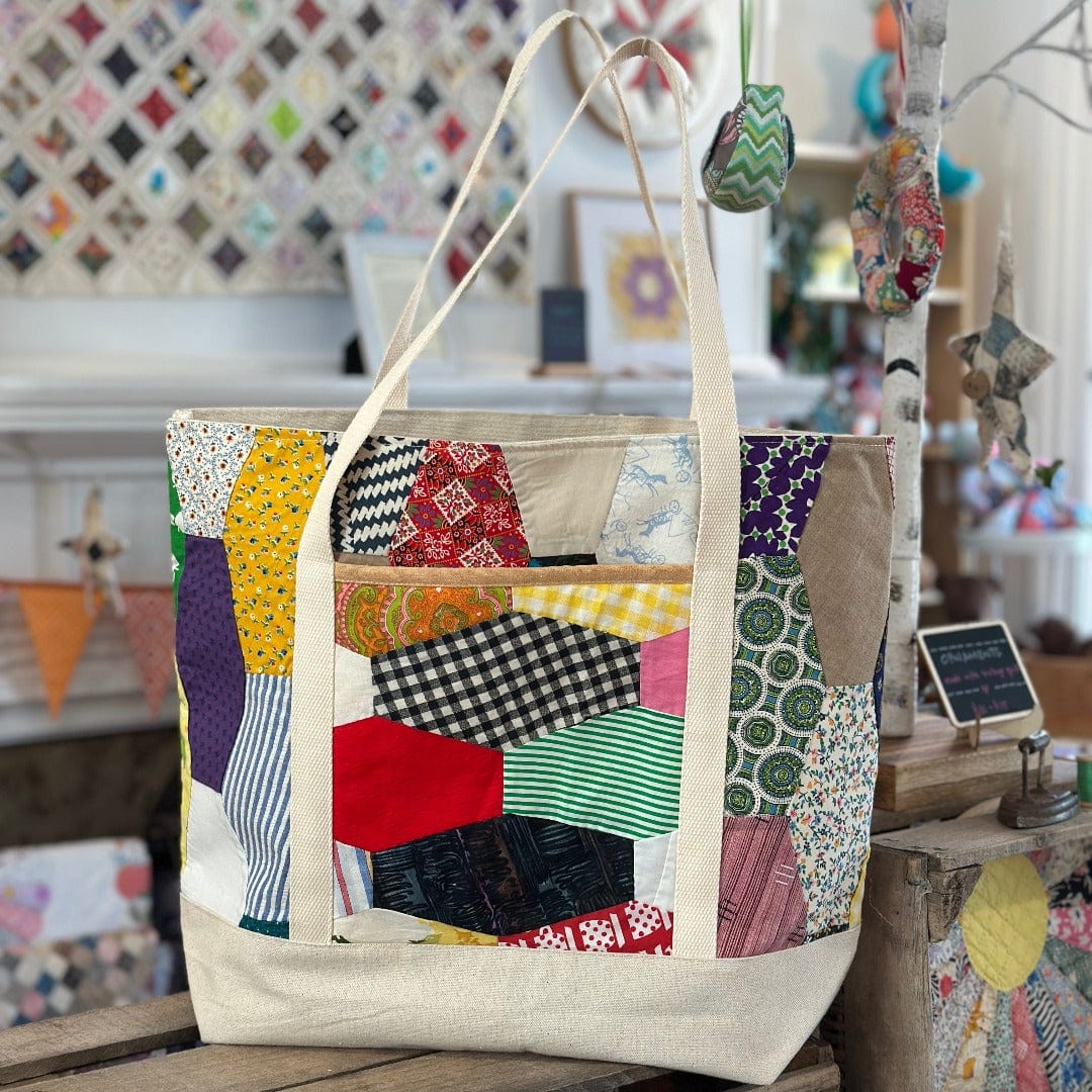 Patchwork tote bag with cream handles.