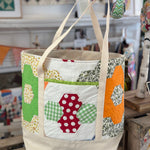 Quilted tote bag with colorful patchwork hexagons.