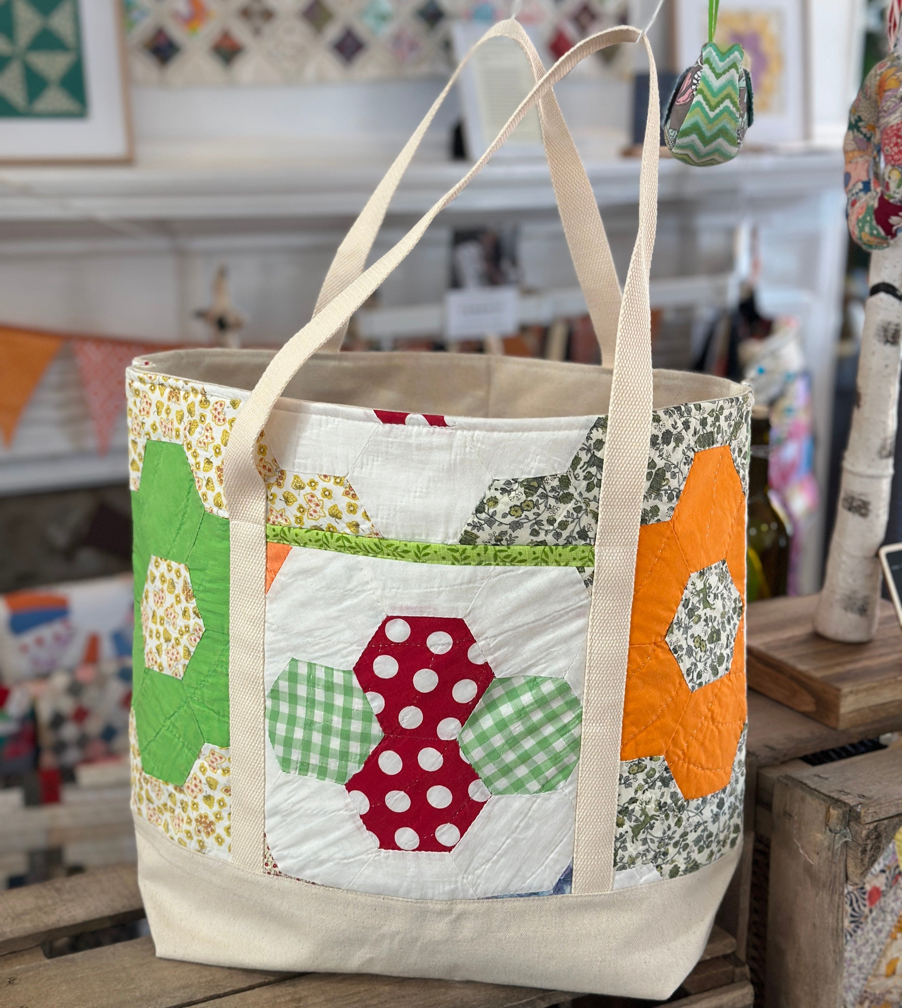 Quilted tote bag with colorful patchwork hexagons.
