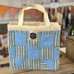 Blue and striped patchwork tote bag with handles.