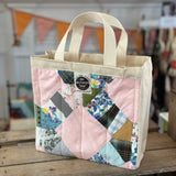 Pink patchwork tote bag with cream handles.