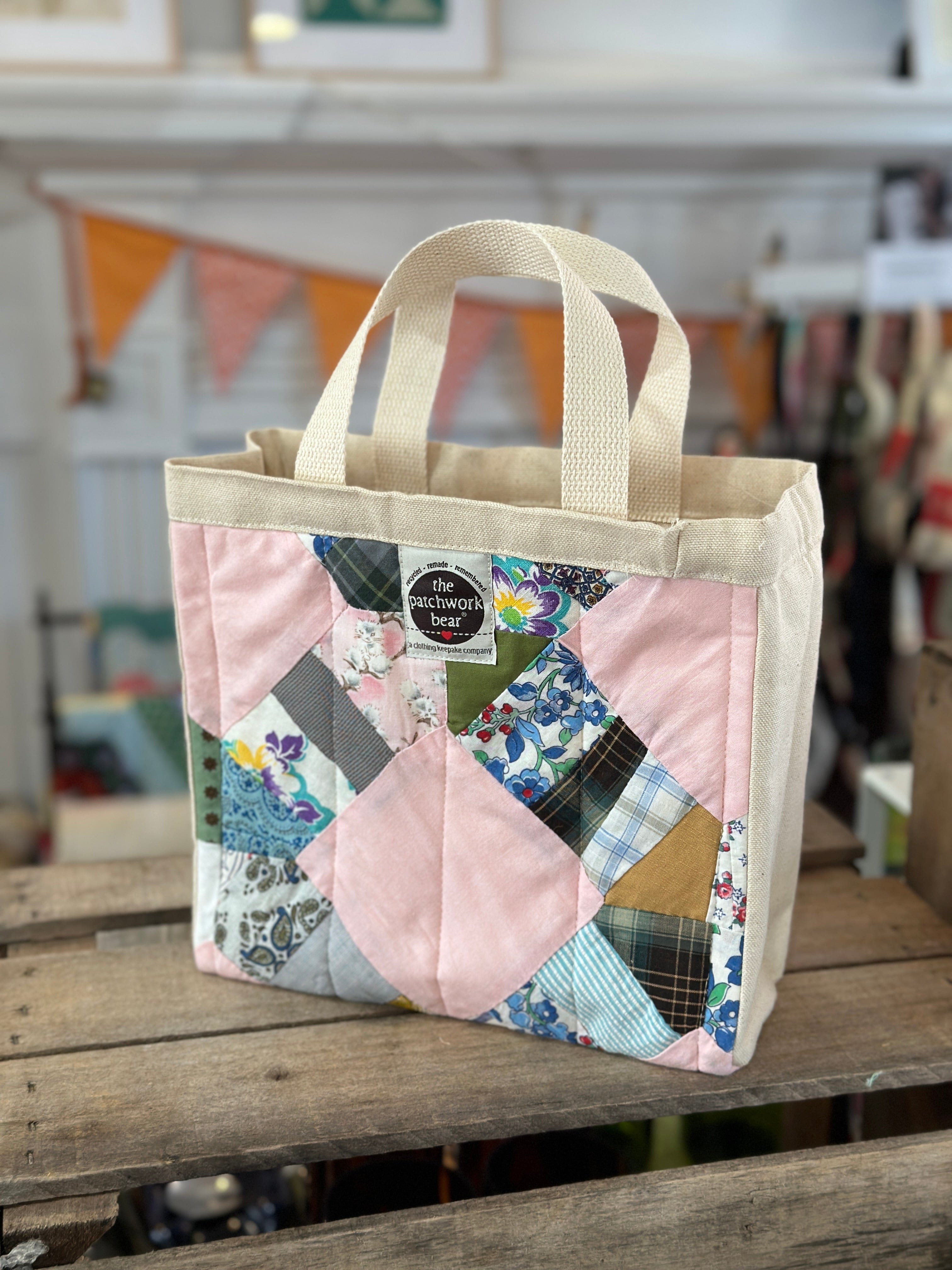 Pink patchwork tote bag with cream handles.