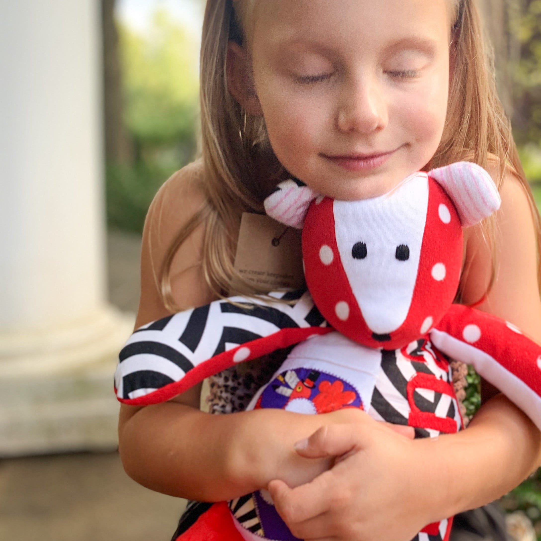 Girl hugging her memory bear made with favorite clothes