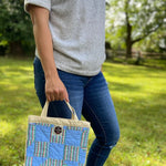 Woman holding blue patchwork handbag, Sep 12, 2023