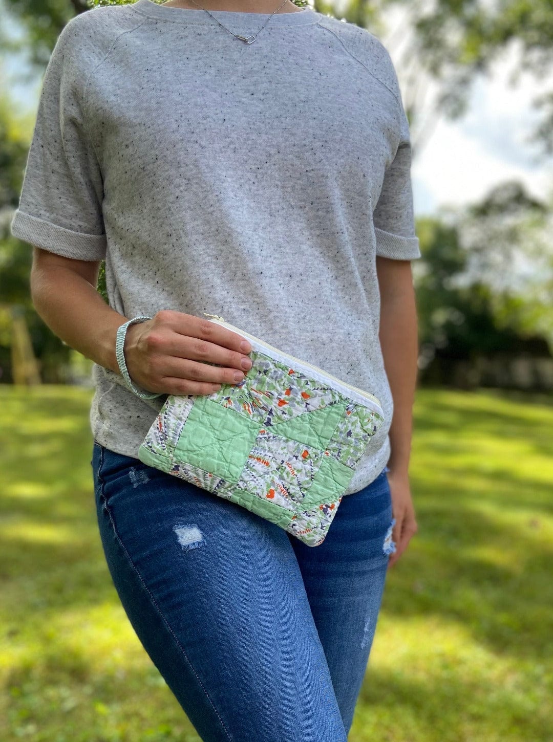 Woman holding quilted clutch, photo Sept 12, 2023
