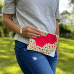 Woman holding red floral clutch, Sept 12, 2023 photo