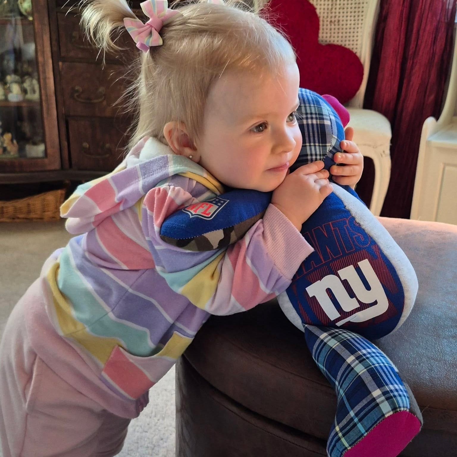 Girl hugging her patchwork bear made from her grandfather's clothes