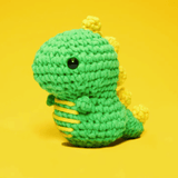 Crocheted green dinosaur toy on yellow background, screenshot from June 15