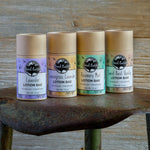 Four lotion bars on a rustic surface.