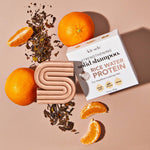 Oranges, shampoo bar, and product box on a surface.
