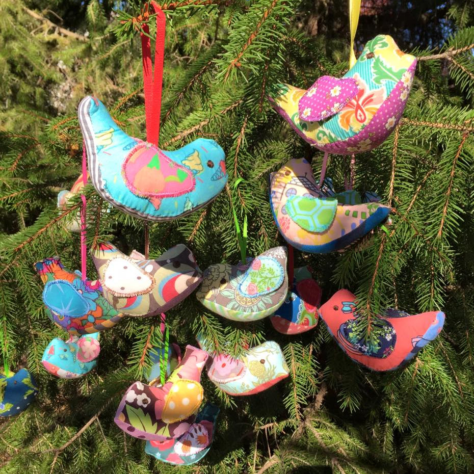 Fabric bird ornaments hanging on a tree.