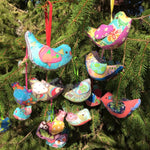 Colorful bird ornaments hanging in a tree.