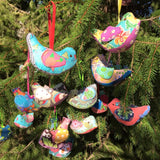 Colorful bird ornaments hanging in a tree.