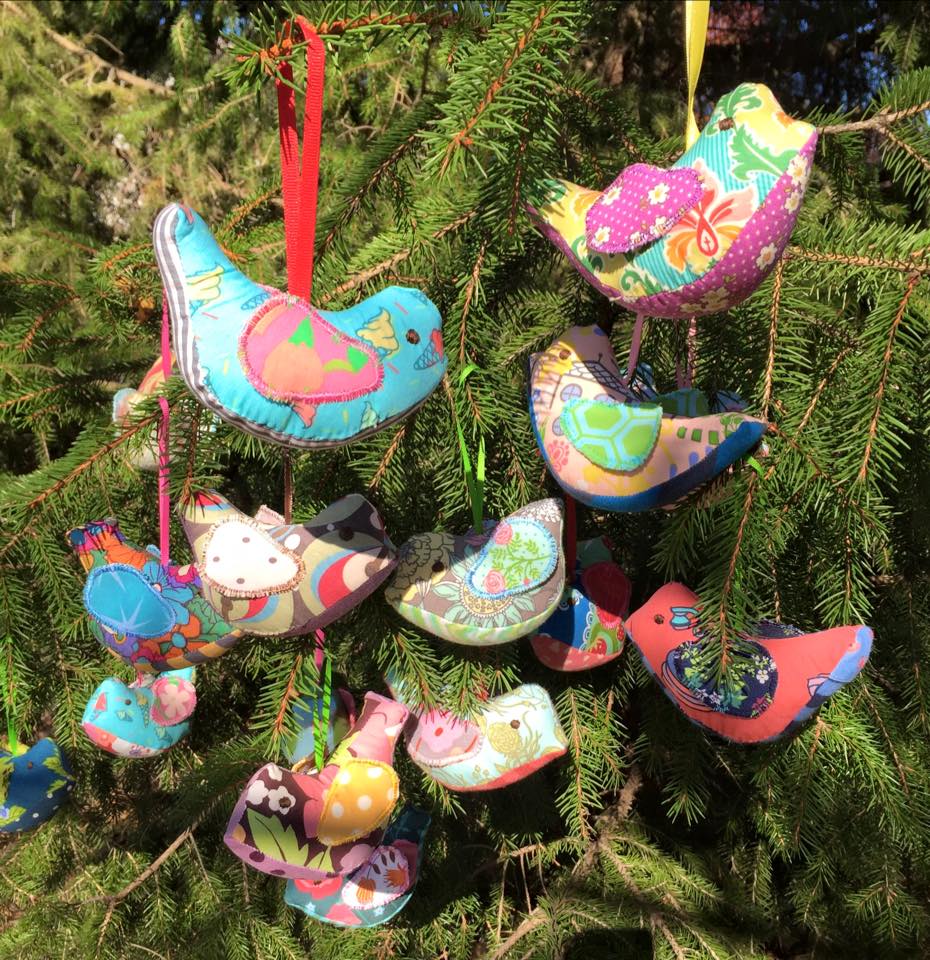 Colorful bird ornaments hanging in a tree.