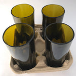 Four green glasses in a cardboard carrier.