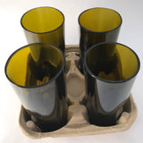 Four green glasses in a cardboard carrier.