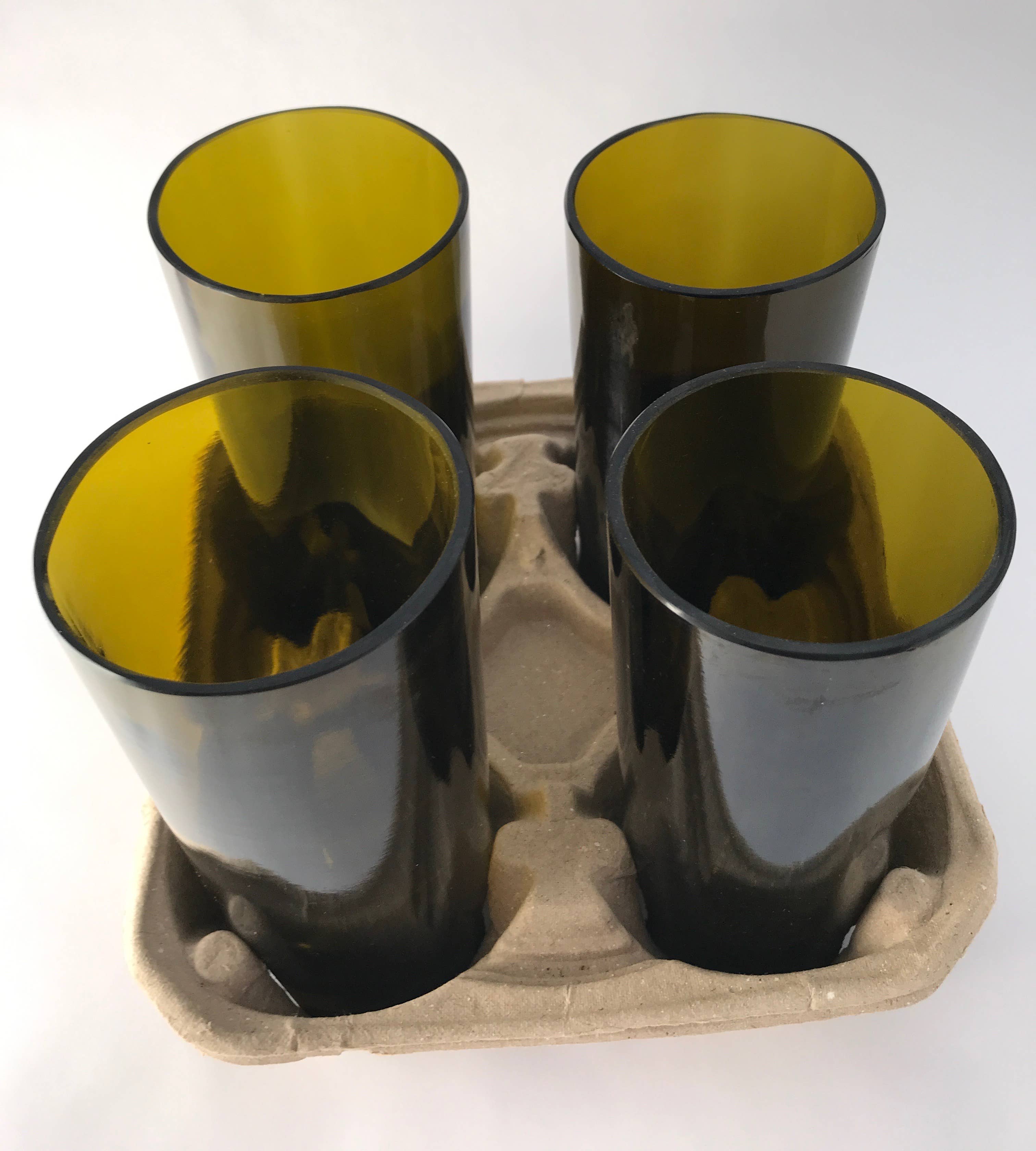 Four green glasses in a cardboard carrier.