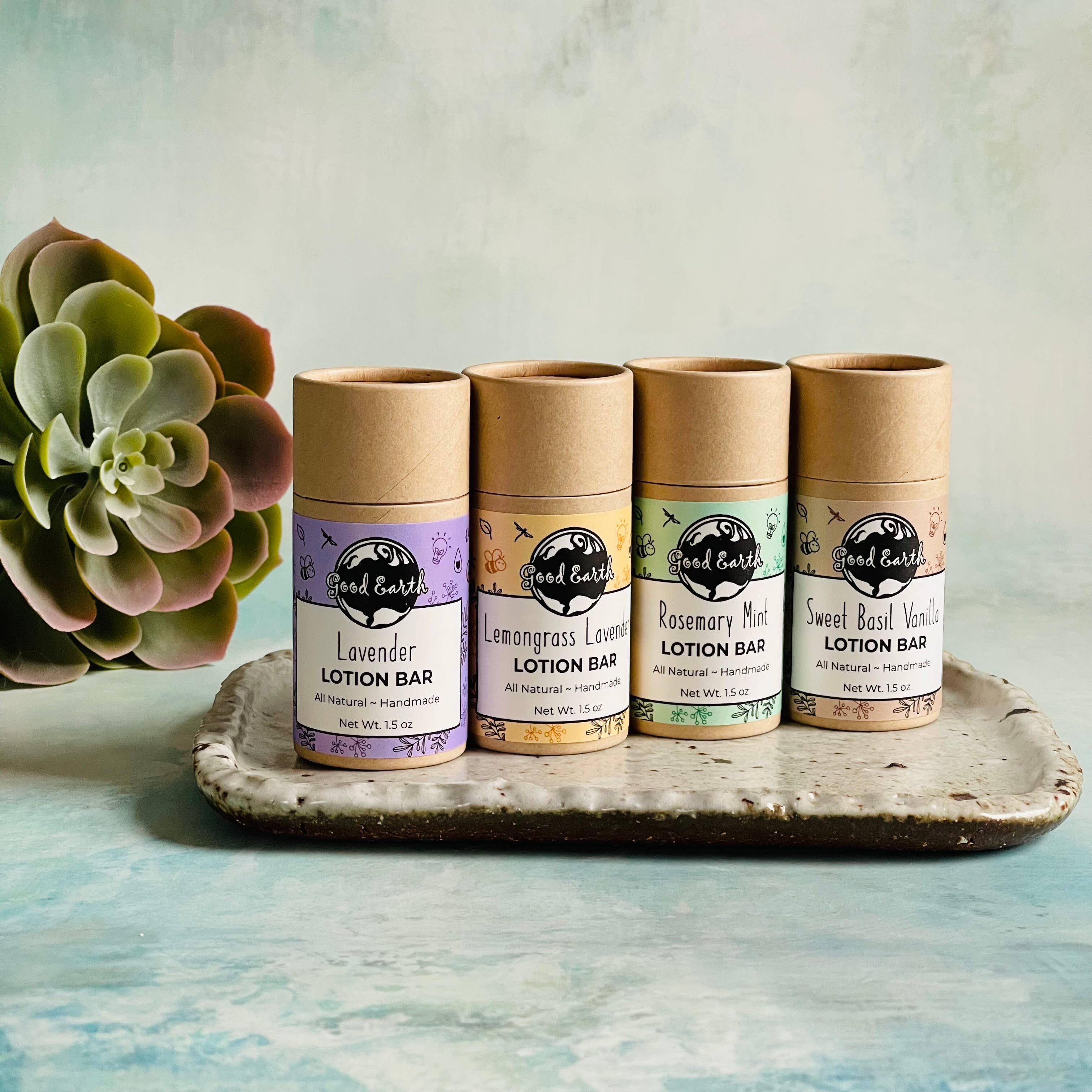 Four lotion bars on a tray next to a succulent.