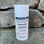 White deodorant stick with label on a rock wall.