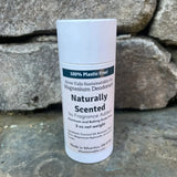 White deodorant stick with label on a rock wall.