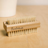 Wooden nail brush on a wooden surface.