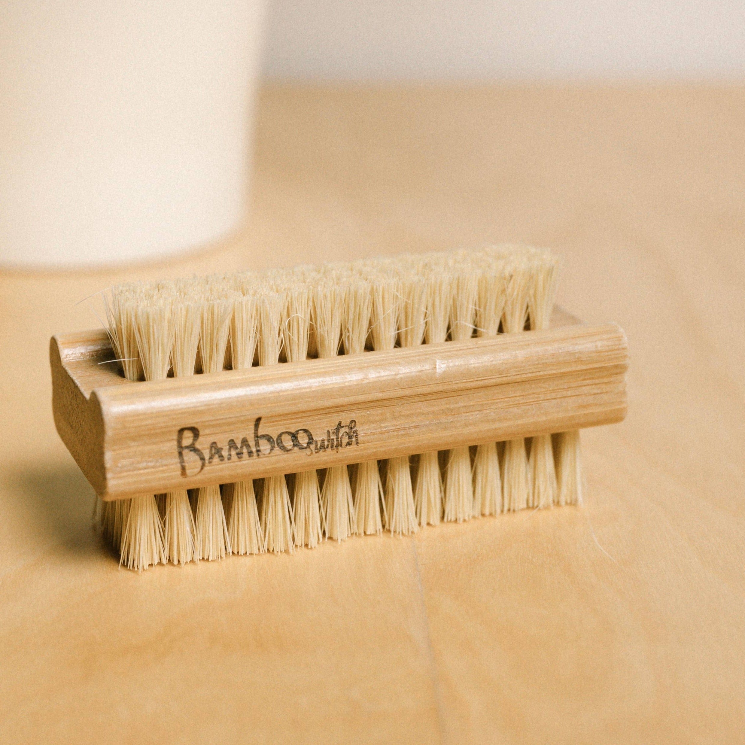 Wooden nail brush on a wooden surface.
