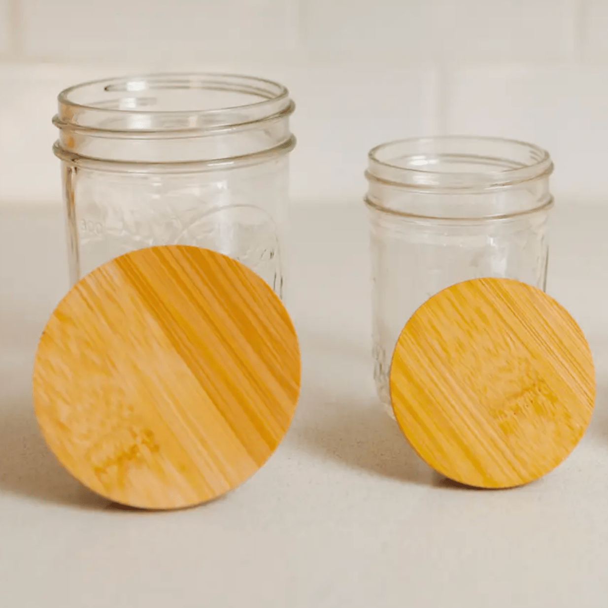Two mason jars with wooden lids.
