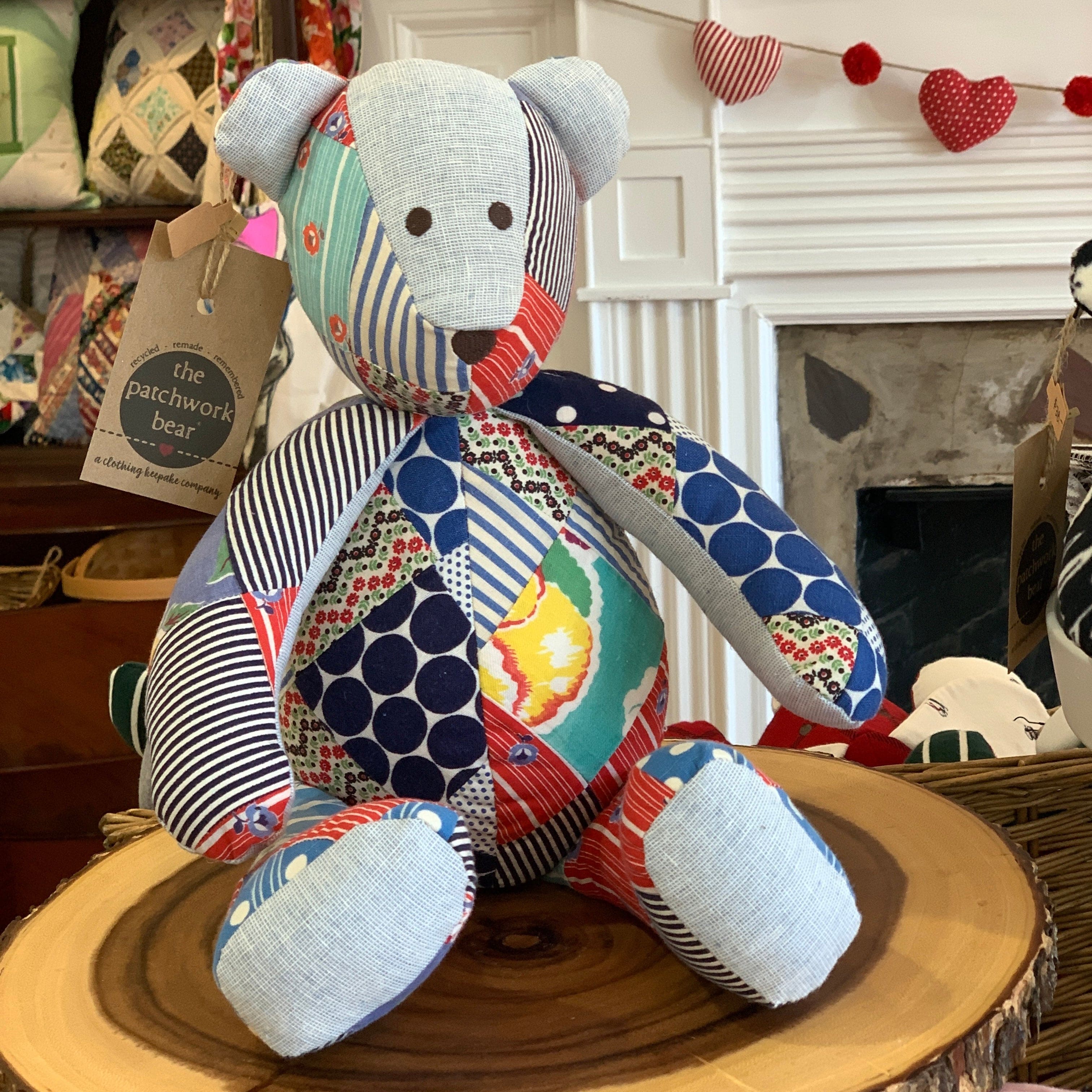 Patchwork teddy bear on a wooden slice.