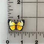 Yellow butterfly patch next to a ruler.