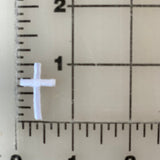 Small white cross next to a ruler.